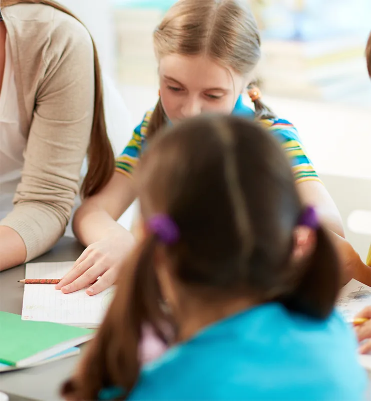 Therapeutin unterstützt Kinder beim gemeinsamen Lernen